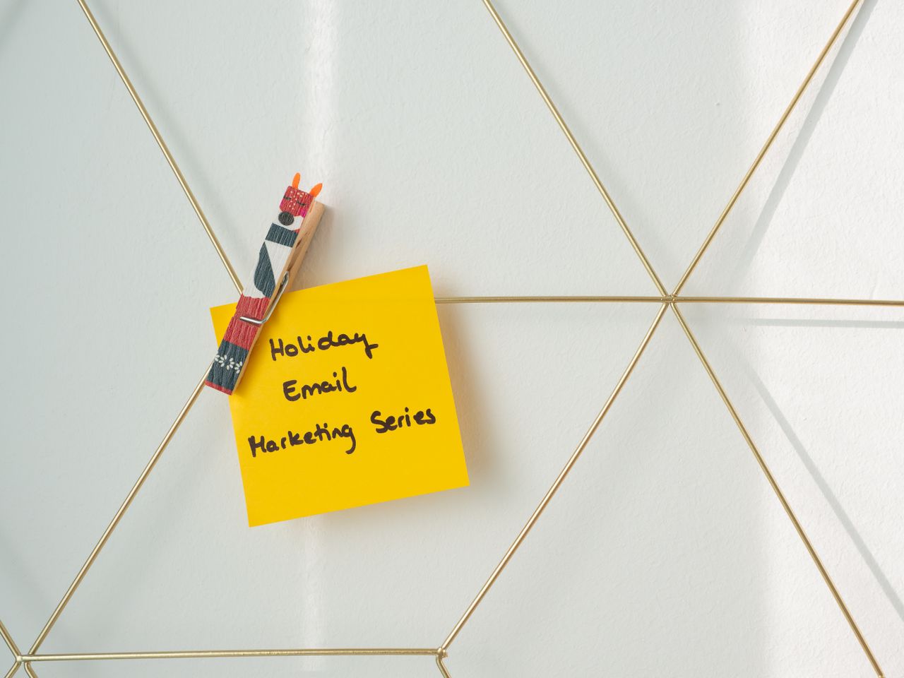 about-us-01 Bright yellow sticky note with holiday email marketing message clipped to a wireframe wall.